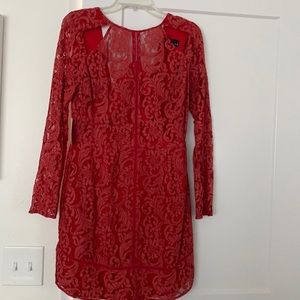 Lace long sleeve dress with cutouts in the front and a low back with zipper.